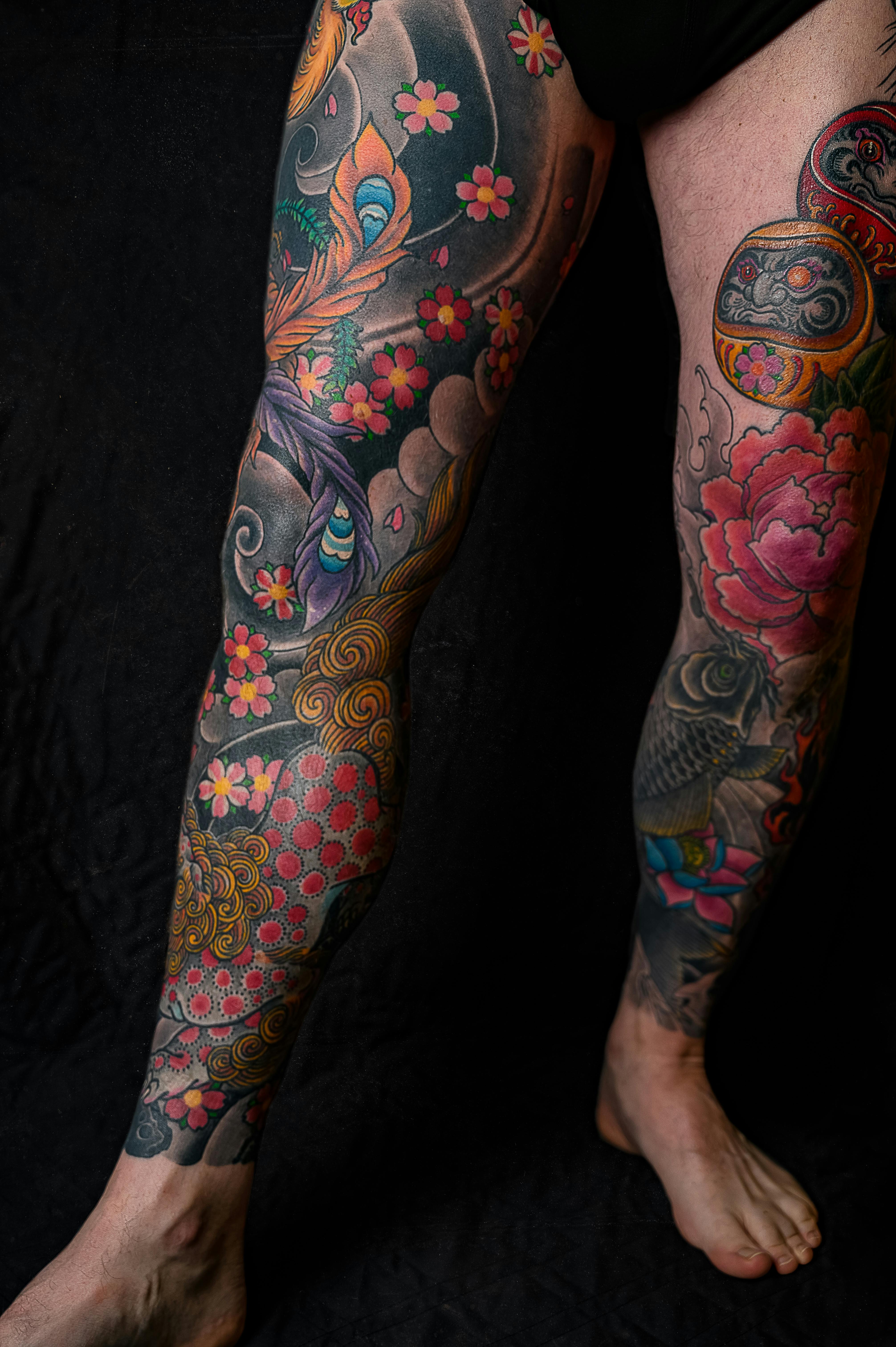 Penas de homem totalmente tatuadas com os temas: flores e espaço.